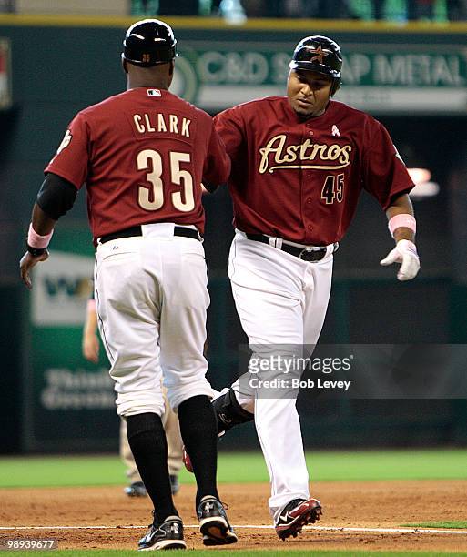 Carlos Lee of the Houston Astros is congratulated by third base coach Dave Clark after hitting a home run in the sixth inning against the San Diego...