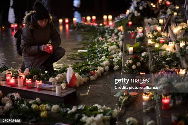 Woman places a candle at the memorial commemorating the victims of a terror attack one year ago on the Christmas market on Breitscheidsplatz in...