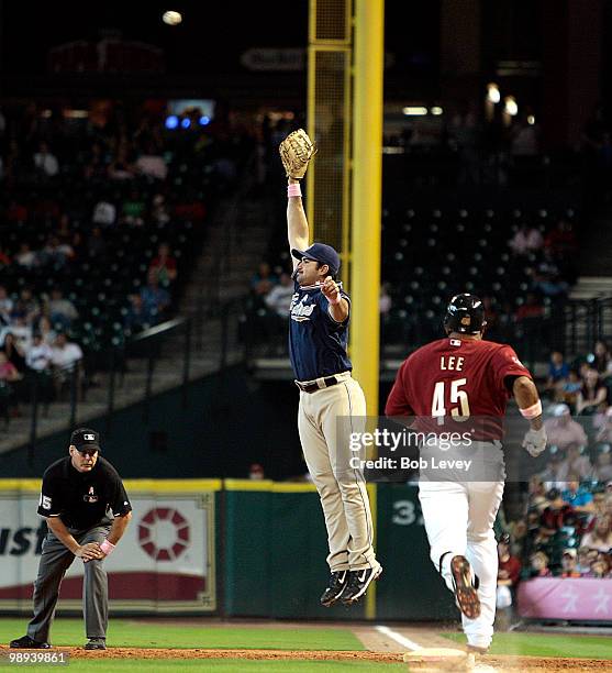 Carlos Lee of the Houston Astros is safe at first base on an infield hit after shortstop Jerry Hairston, Jr. #15 of the San Diego Padres over threw...