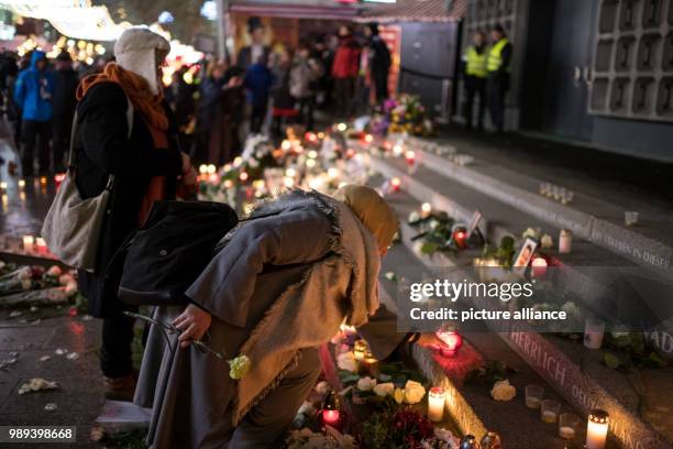 Women place a candles at the memorial commemorating the victims of a terror attack one year ago on the Christmas market on Breitscheidsplatz in...