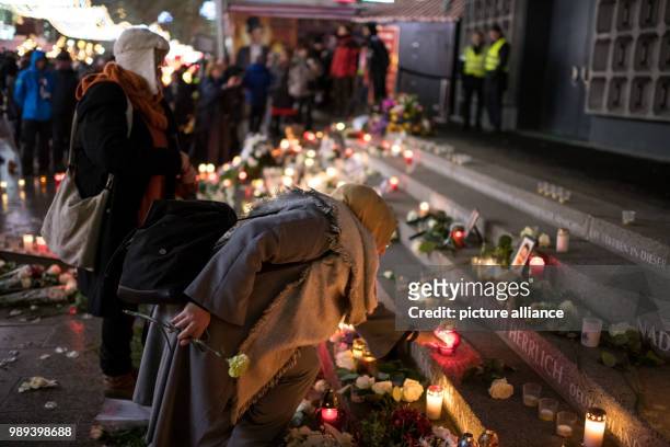 Women place candles at the memorial commemorating the victims of a terror attack one year ago on the Christmas market on Breitscheidsplatz in Berlin,...