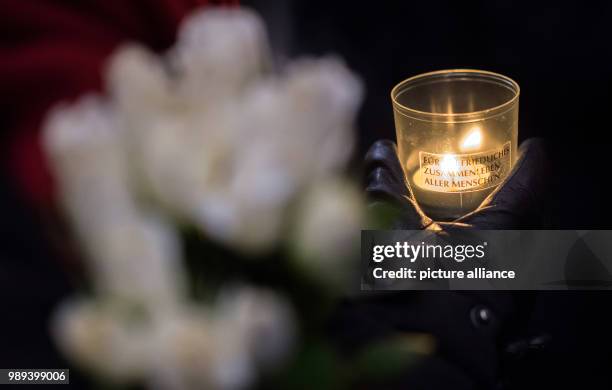 Woman holds a candle at the memorial commemorating the victims of a terror attack one year ago on the Christmas market on Breitscheidsplatz in...