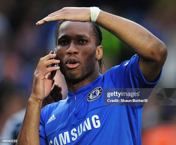 Didier Drogba of Chelsea talks on his mobile phone as he celebrates winning the title after the Barclays Premier League match between Chelsea and...