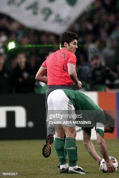 Referee Massimo Busacca is pointed by a laser beam in the eye during a first knock-out round, 2nd leg Champions League football game between...