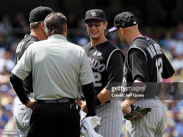 Shortstop Troy Tulowitzki of the Colorado Rockies is attended to after injuring himself while trying to complete a double play in the fifth inning...