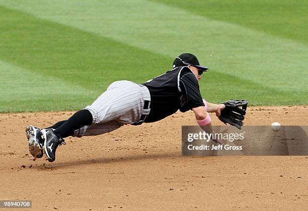 Second baseman Clint Barmes of the Colorado Rockies dives for, but can't make a play on a ball that deflected off the pitchers glove and into right...