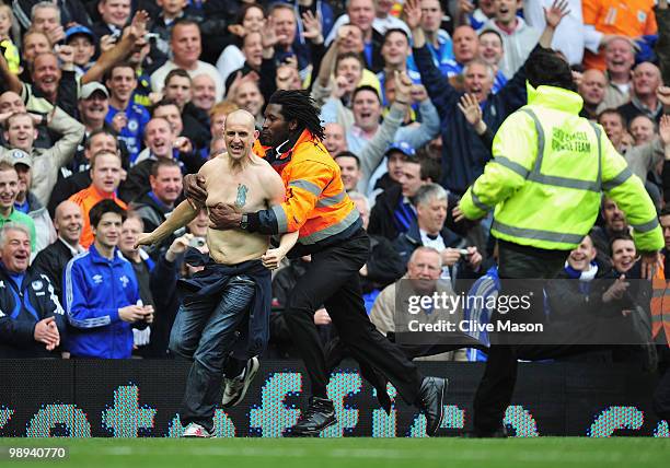 Pitch invader is apprehended during the Barclays Premier League match between Chelsea and Wigan Athletic at Stamford Bridge on May 9, 2010 in London,...