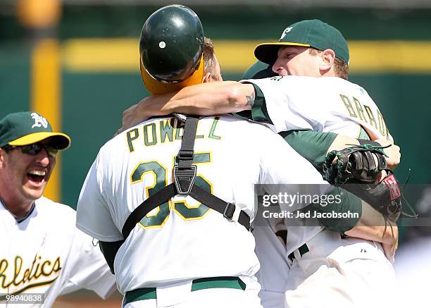 Dallas Braden of the Oakland Athletics celebrates with his catcher Landon Powell and Adam Rosales after pitching a perfect game against the Tampa Bay...