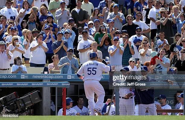 Russell Martin of the Los Angeles Dodgers receives high fives in the dugout after hitting a solo homerun in the eighth inning against the Colorado...