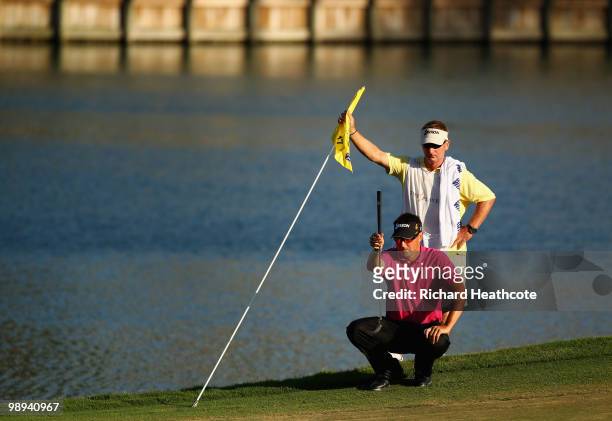 Robert Allenby of Australia lines up his putt on the 17th green with the help of his caddie Colin Burwood during the final round of THE PLAYERS...