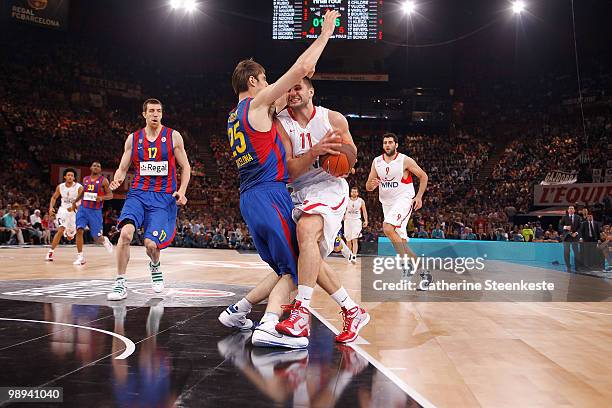 Linas Kleiza, #11 of Olympiacos Piraeus competes with Erazem Lorbek, #25 of Regal FC Barcelona during the Euroleague Basketball Final Four Final Game...