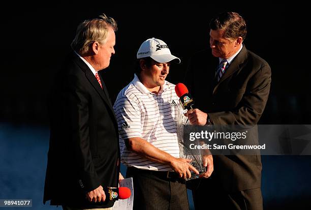 Johnny Miller and Dan Patrick of NBC award Tim Clark of South Africa the trophy during the trophy presentation after he won THE PLAYERS Championship...