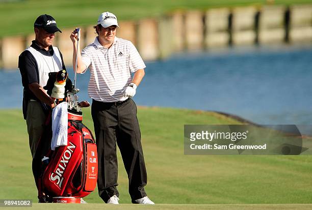 Tim Clark of South Africa pulls a club from his bag while alongside caddie Steve Underwood on the fairway of the 18th hole during the final round of...