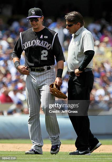 Shortstop Troy Tulowitzki of the Colorado Rockies is attended to after injuring himself while trying to complete a double play in the fifth inning...