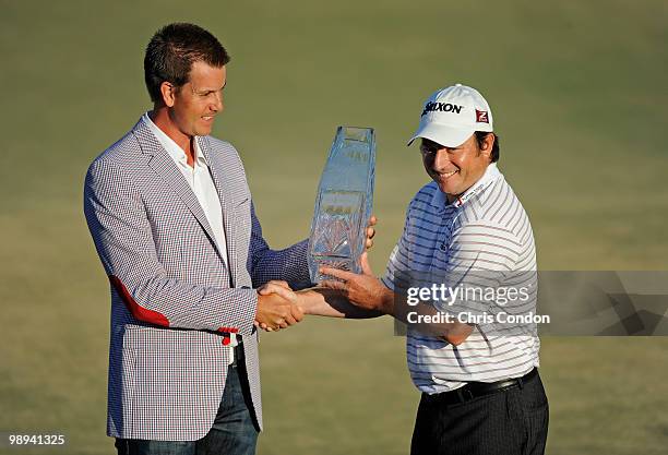 Defending champion Henrik Stenson of Sweden hands the tournament trophy to Tim Clark of South Africa after Clark won THE PLAYERS Championship on THE...