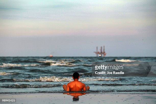 Josiah Boudreaux relaxes in the surf as efforts continue to contain the massive oil spill on May 9, 2010 in Lafourche Parish, Louisiana. The wellhead...