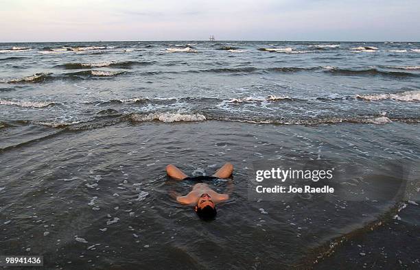 Josiah Boudreaux relaxes in the surf as efforts continue to contain the massive oil spill on May 9, 2010 in Lafourche Parish, Louisiana. The wellhead...