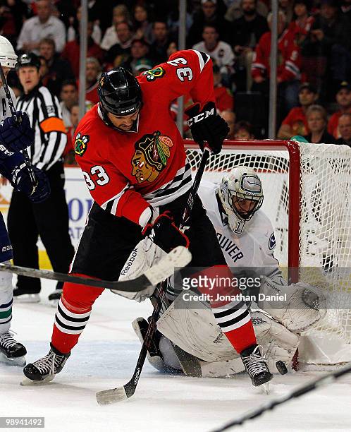 Dustin Byfuglien of the Chicago Blackhawks tries to slip the puck past Roberto Luongo of the Vancouver Canucks in Game Five of the Western Conference...