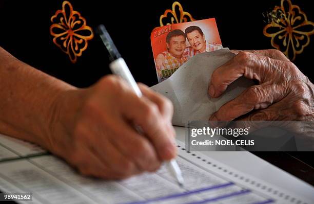 Lucina Ejercito cousin of presidential candiudate and former president Joseph Estrada fills in her ballot at an elementary school in San Juan, east...