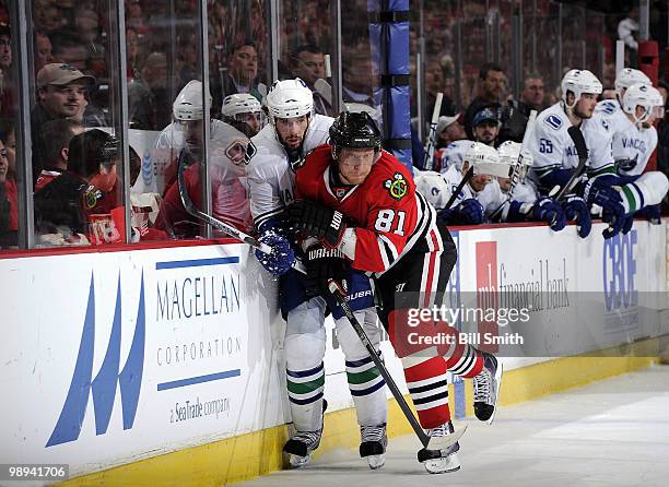 Marian Hossa of the Chicago Blackhawks pushes Ryan Kesler of the Vancouver Canucks into the boards at Game Five of the Western Conference Semifinals...