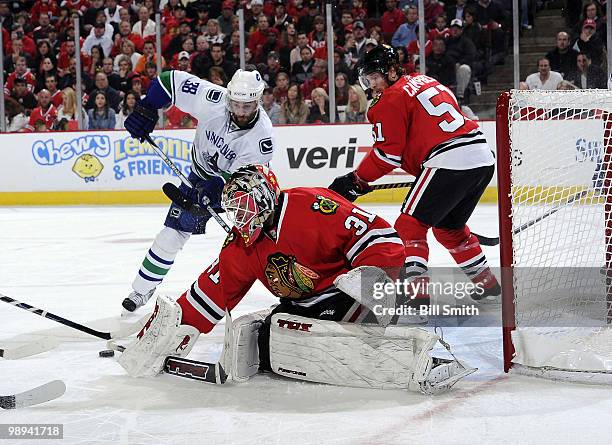 Goalie Antti Niemi of the Chicago Blackhawks protects the net as teammate Brian Campbell and Pavol Demitra of the Vancouver Canucks watch for the...