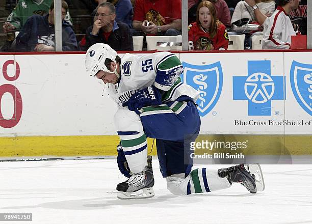 Shane O'Brien of the Vancouver Canucks kneels down in pain after taking a hit from Chicago Blackhawks' #33 Dustin Byfuglien's stick at Game Five of...