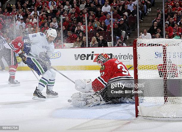 Goalie Antti Niemi of the Chicago Blackhawks gets in position to stop the puck as Ryan Johnson of the Vancouver Canucks approaches, at Game Five of...