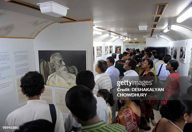 Indian visitors watch an exhibition on the life and works of Nobel laureate poet Rabindranath Tagore housed in a railway coach to celebrate poet's...