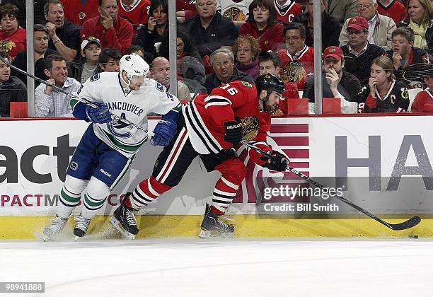 Andrew Ladd of the Chicago Blackhawks approaches the puck as Jannik Hansen of the Vancouver Cancuks watches from behind at Game Five of the Western...