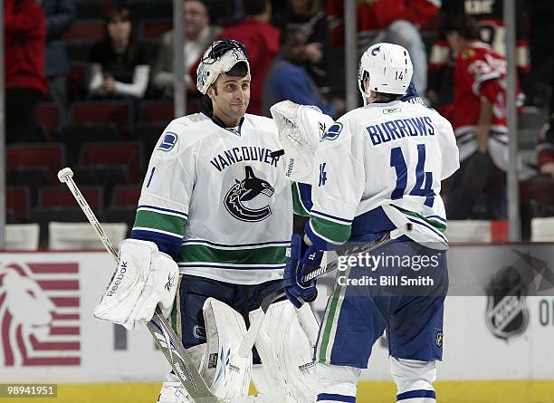 Goalie Roberto Luongo of the Vancouver Canucks celebrates with teammate Alexandre Burrows after winning against the Chicago Blackhawks at Game Five...