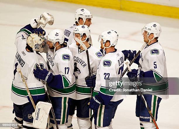 Ryan Kesler of the Vancouver Canucks congratulates goalie Roberto Luongo after a win over the Chicago Blackhawks while teammates including Daniel...