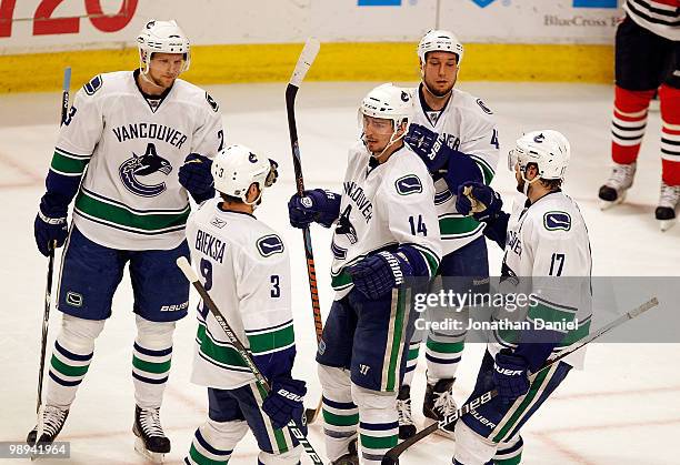 Alexandre Burrows of the Vancouver Canucks is surrounded by congratulatory teammates Alexander Edler, Kevin Bieksa, Kyle Wellwood and Ryan Kesler...