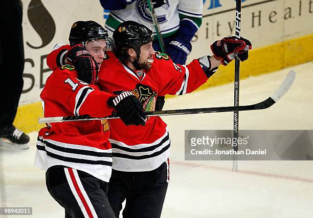 Jonathan Toews and Adam Burish of the Chicago Blackhawks celebrate Toews' 3rd period goal against the Vancouver Canucks in Game Five of the Western...