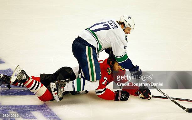 Ryan Kelser of the Vancouver Canucks skates over Brent Seabrook of the Chicago Blackhawks in Game Five of the Western Conference Semifinals during...