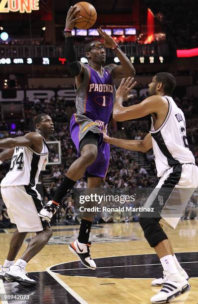 Forward Amar'e Stoudemire of the Phoenix Suns takes a shot against Tim Duncan and Antonio McDyess of the San Antonio Spurs in Game Four of the...