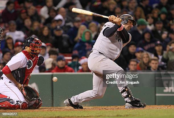 Jorge Posada of the New York Yankees strikes out swinging as catcher Victor Martinez of the Boston Red Sox fields the ball at Fenway Park on May 9,...