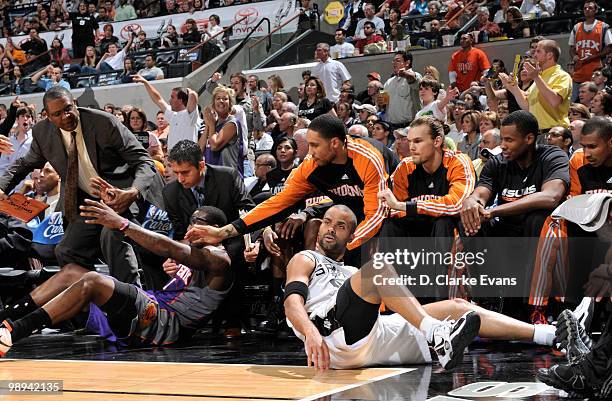 Tony Parker of the San Antonio Spurs chases after a loose ball and falls out of bounds with Amar'e Stoudemire of the Phoenix Suns in Game Four of the...
