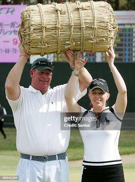Morgan Pressel of United States and her caddie pose for photographs holding a rice bale as the extra prize after winning the World Ladies...