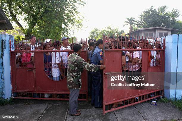 Filipino voters wait to enter a polling center to cast votes on May 10, 2010 in the southern town of Kiamba, Sarangani Province. The country goes to...