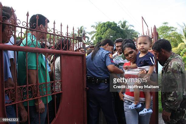 Filipino voters enter a polling center to cast votes on May 10, 2010 in the southern town of Kiamba, Sarangani Province. The country goes to the...