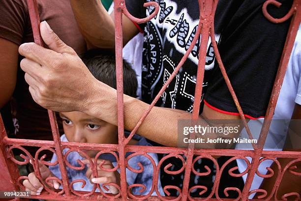 Filipino voters wait to enter a polling center to cast votes on May 10, 2010 in the southern town of Kiamba, Sarangani Province. The country goes to...