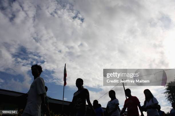 Filipino voters enter a polling center to cast votes on May 10, 2010 in the southern town of Kiamba, Sarangani Province. The country goes to the...