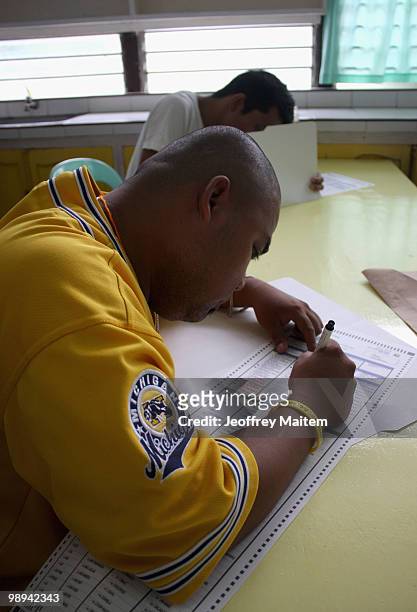 Filipino voters fills in their ballots at polling center on May 10, 2010 in the southern town of Kiamba, Sarangani Province. The country goes to the...