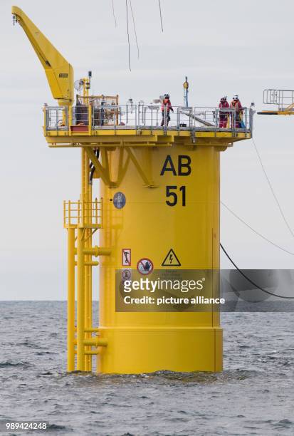 Engineers assemble transition pieces between foundation piles in the Baltic Sea and facilities of the wind farm 'Arkona' off the coast of the island...