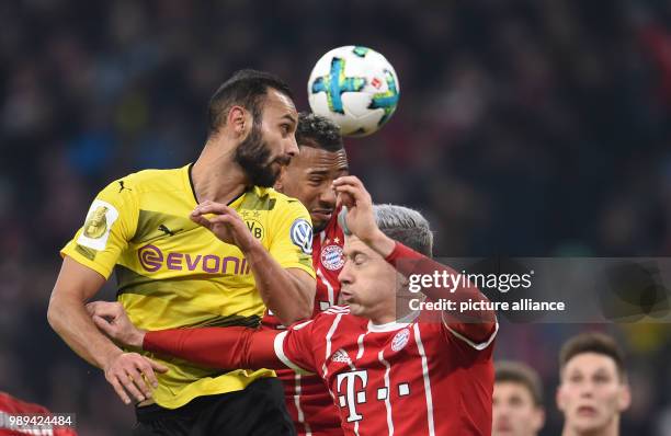 Munich's Jerome Boateng and Robert Lewandowski and Dortmund's Omer Toprak in action during the German DFB Cup soccer match between Bayern Munich and...