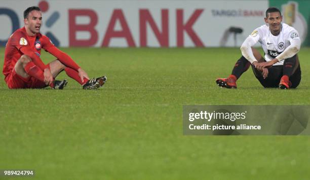 Heidenheim's Robert Strauss and Frankfurt's Sebastien Haller sit on the turf after the German DFB Cup soccer match between 1. FC Heidenheim and...