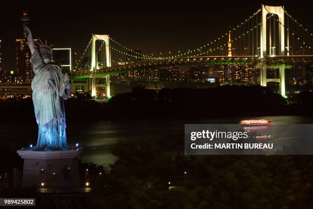 This photo taken on July 1, 2018 shows a replica of the Statue of Liberty and the Rainbow Bridge in Odaiba along Tokyo Bay.