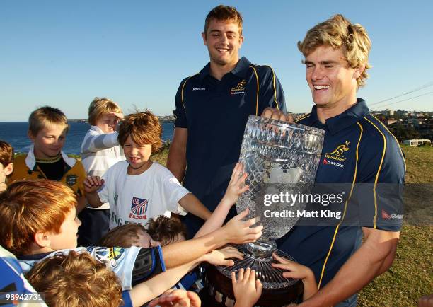 Dean Mumm and Berrick Barnes hold the Cook Cup as local ruby playing children gather round during an ARU press conference to announce the sale of...