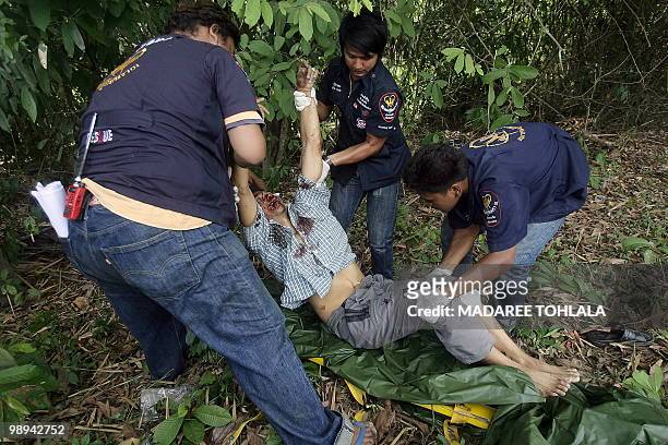 Thai rescuers carry the body of a Muslim man who was shot dead by suspected separatist militants in Thailand's restive southern province of...