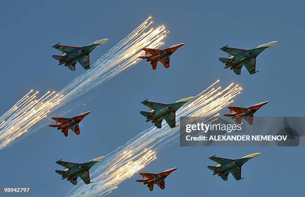 Russian Su-27 and MiG-29 fighter jets shoot flares while flying over St. Basil's Cathedral on Red Square in Moscow on during a Victory Day parade on...